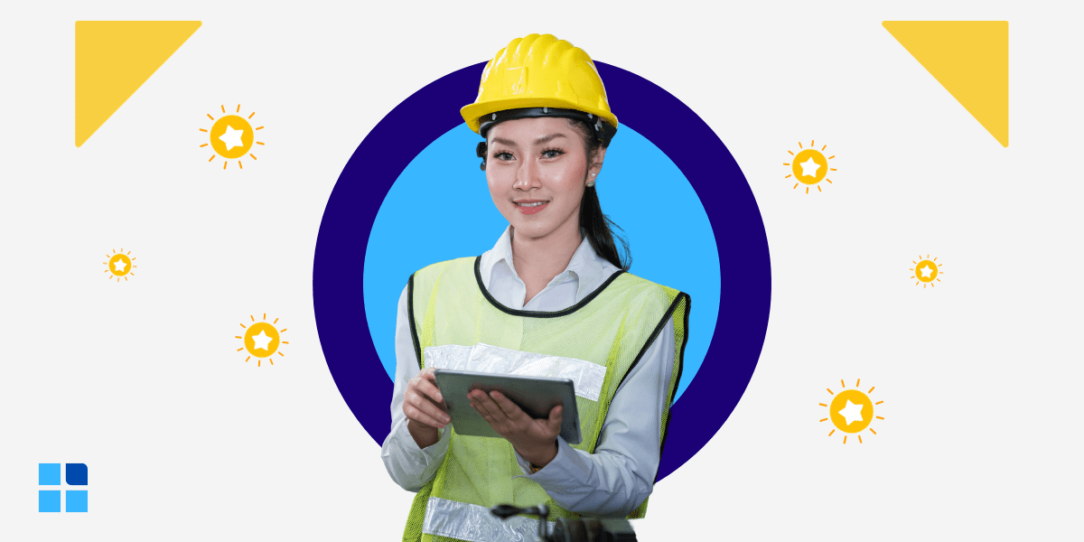 Young woman in construction gear and hard hat holds a tablet, smiling.