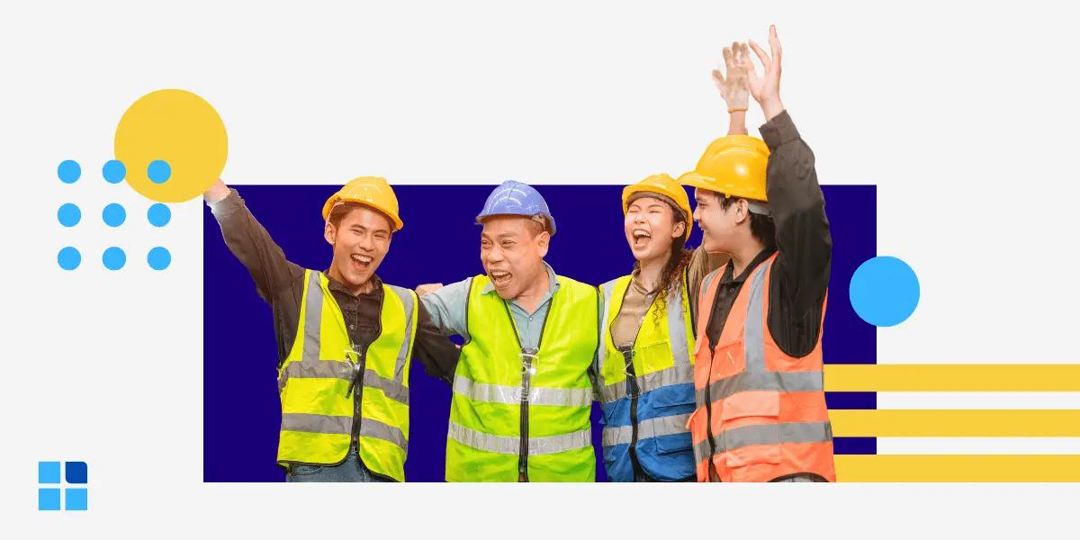 A group of 4 construction workers in bright vests & helmets celebrate with raised arms and smiles.