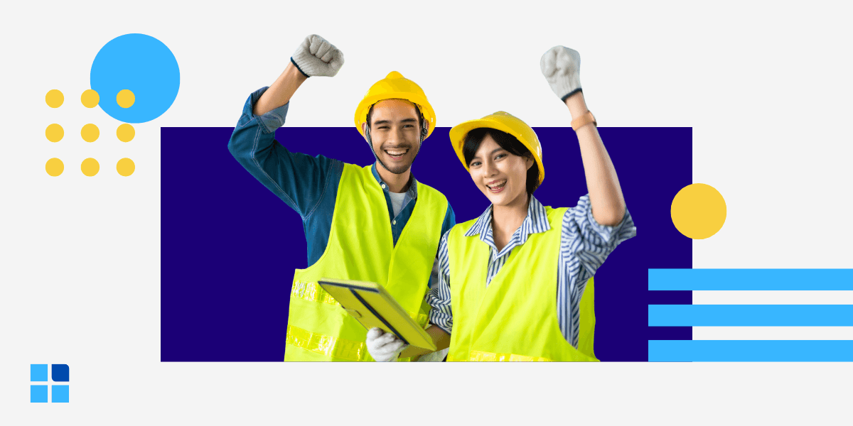 Two construction workers, a man and a woman, cheerfully celebrating with raised fists