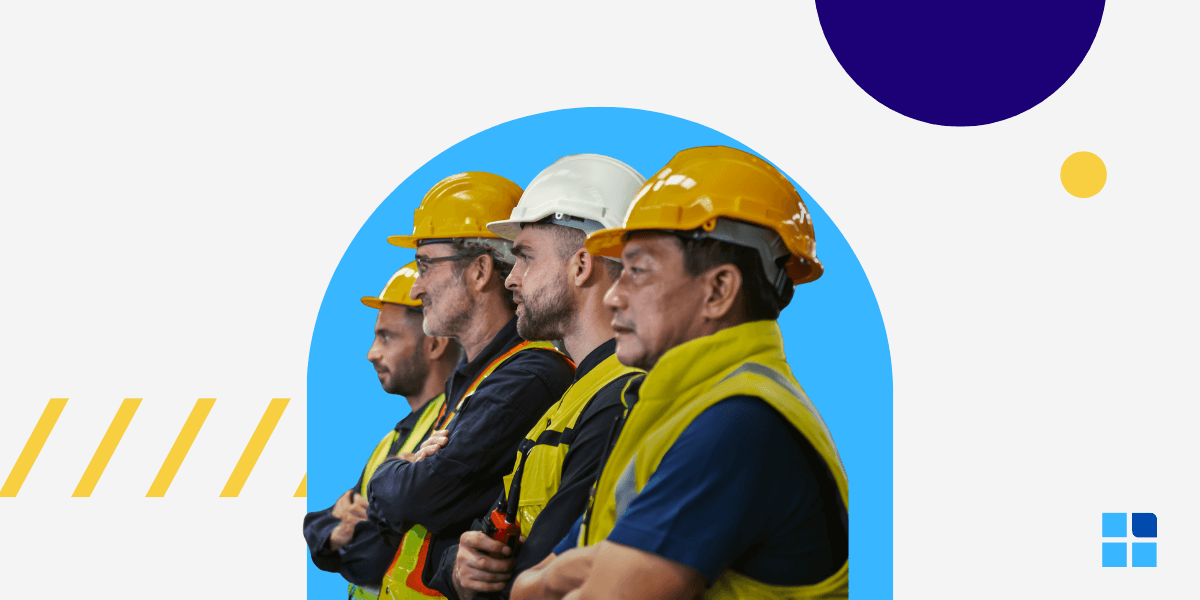 Four construction workers in hard hats and safety vests stand attentively side by side.