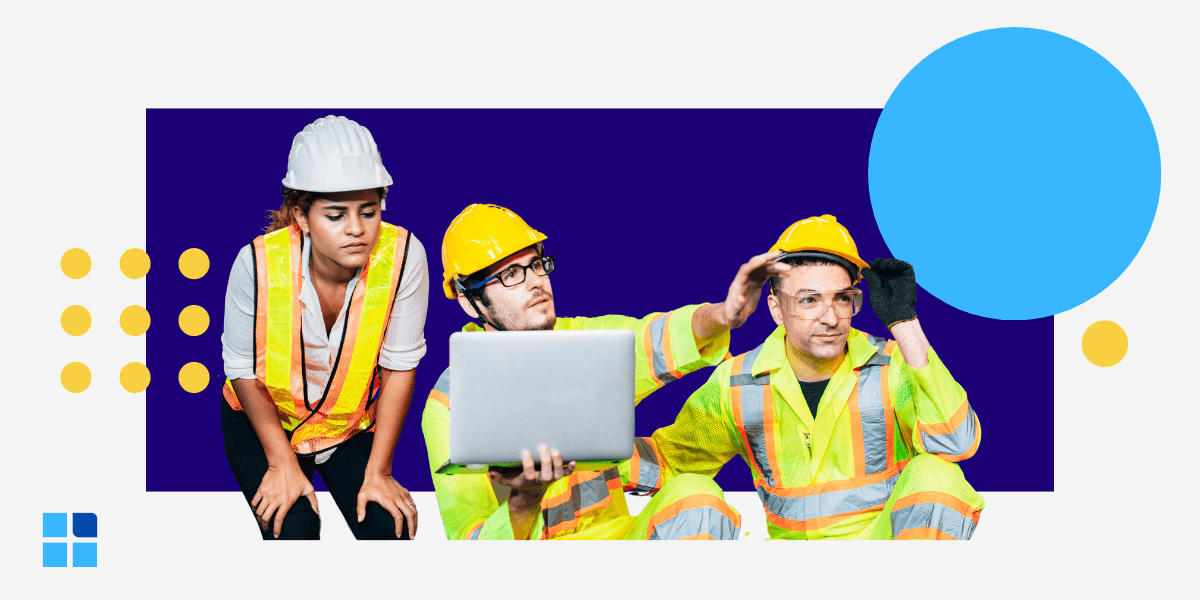Three construction workers wearing safety gear are focused on a laptop.