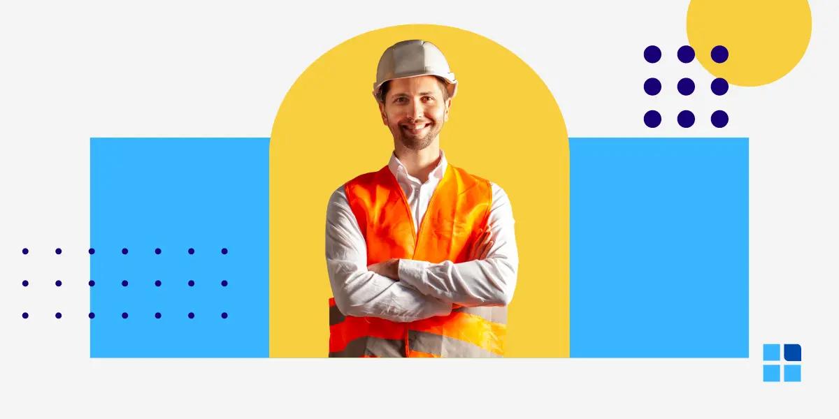 Smiling man in a hard hat and orange vest stands confidently, arms crossed.