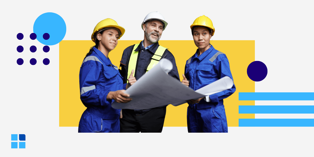 A diverse group of three construction workers in blue uniforms and hard hats discuss blueprints.